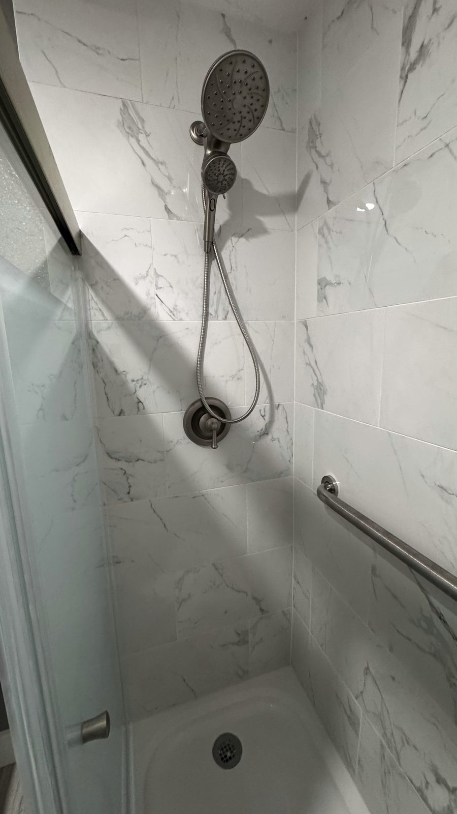 Marble walk-in shower remodel with glass door