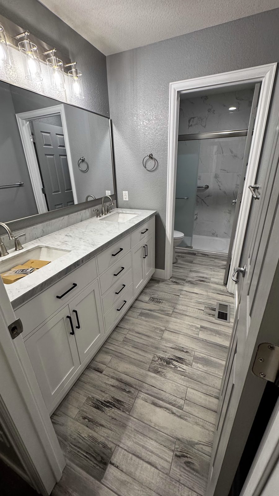 Master bathroom after remodel with finished double vanity and walk-in shower