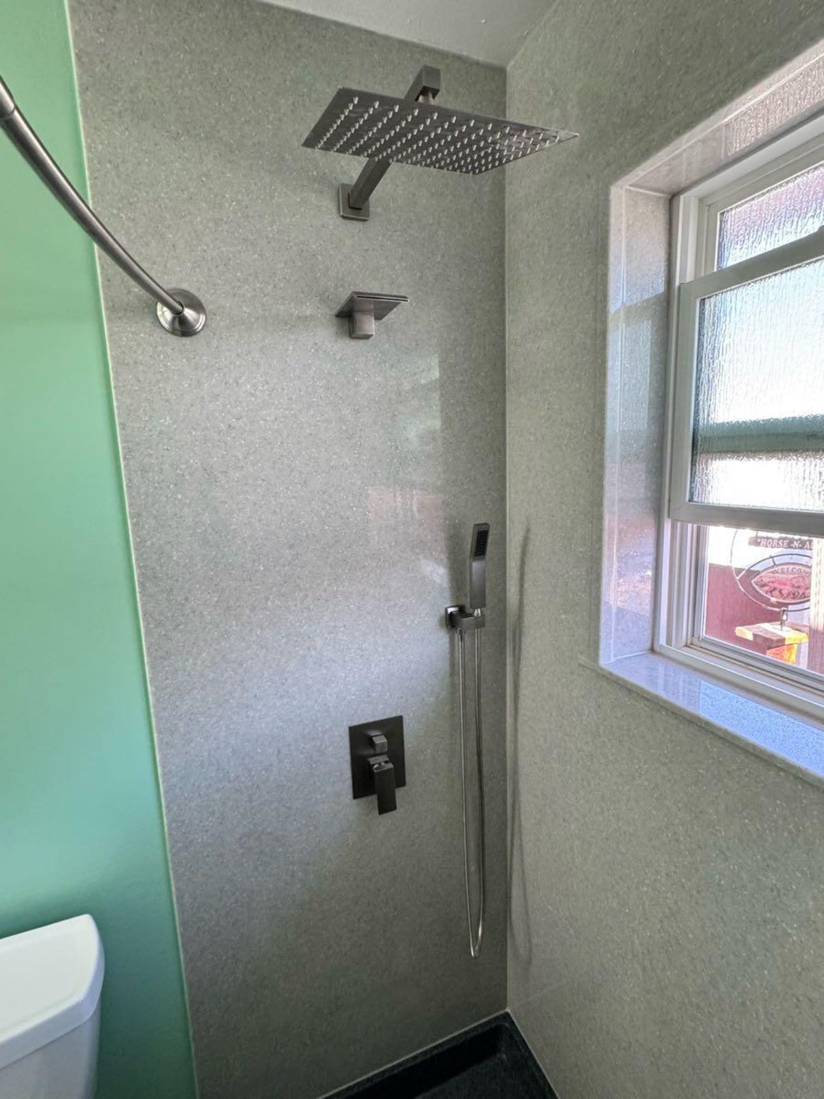 Walk-in shower with marble tile and rainfall fixture